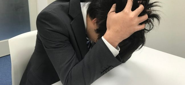 頭を抱える男性